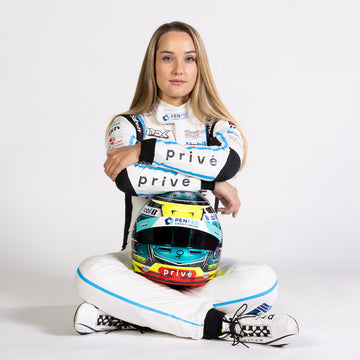 Sabré Cook holding a helmet in her privé racing suit